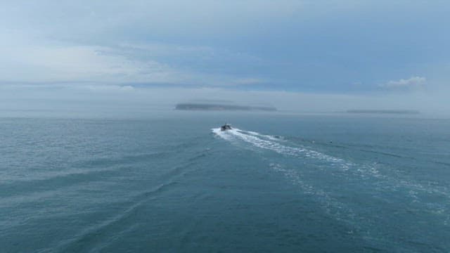 Boat navigating through misty seascape