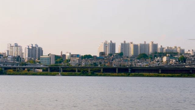 Calm urban skyline with a Hangang River in the foreground during the late afternoon