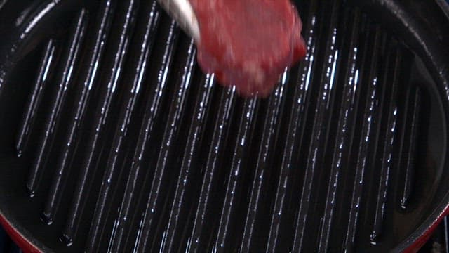 Grilling a juicy beef steak on a hot pan
