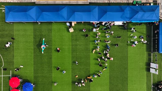 People gathered at the event venue with red and blue parasols