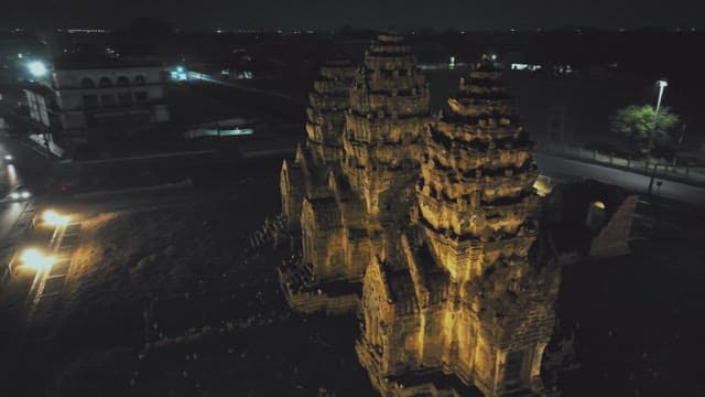 Night View of Illuminated Ancient Temple Surrounded by Modern City