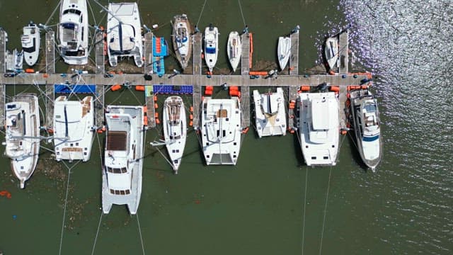 Yachts docked at a marina on a sunny day