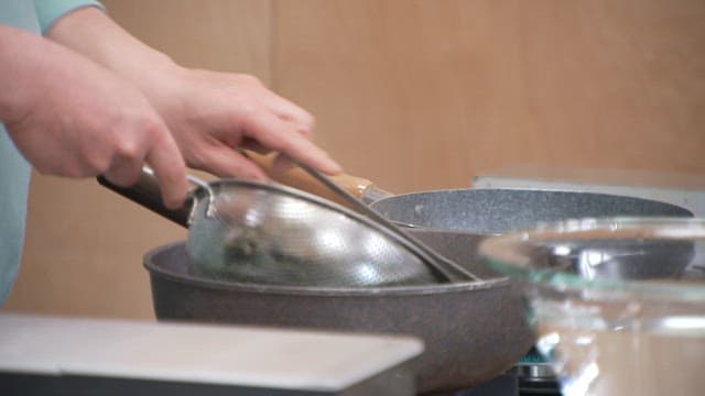 Process of removing boiled hijiki from pot and rinsing it in cold water