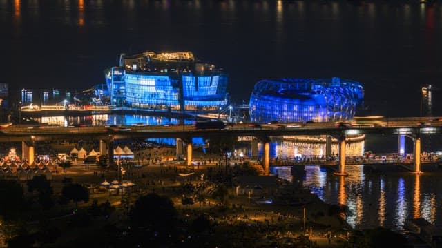 Nighttime view of riverside park with colorful lights