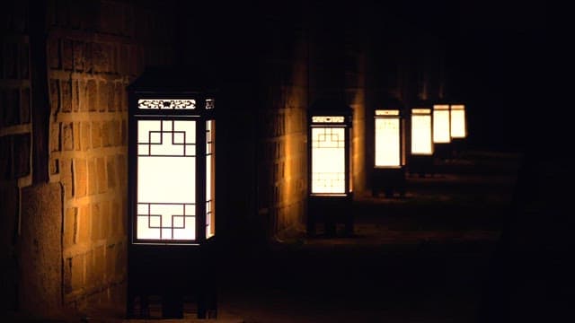Traditional lanterns illuminating a dark street.