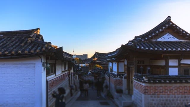 People visiting Bukchon Hanok Village at sunset