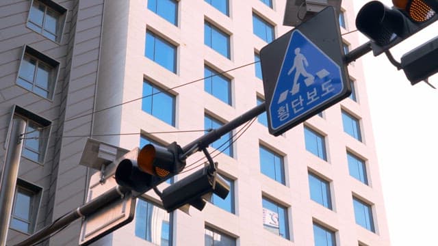 Signal in front of a building with a flashing yellow light
