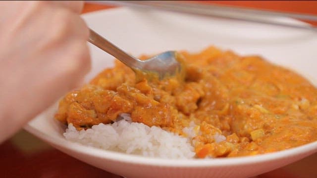Spoon scooping curry over rice