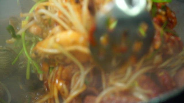Cooking seafood with bean sprouts in a pan