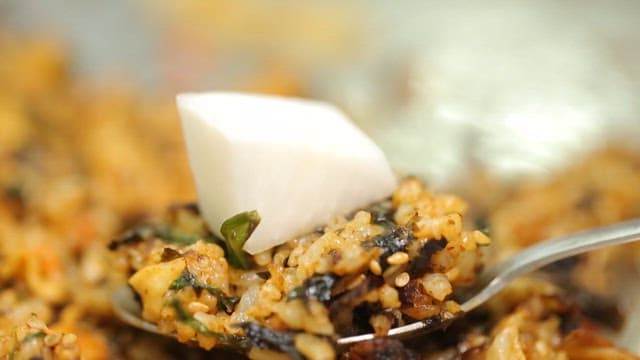 Spoonful of griddled stir-fried rice served with pickled radish