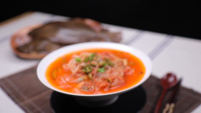 Bowl of spicy fish porridge with vegetables and fresh flounder