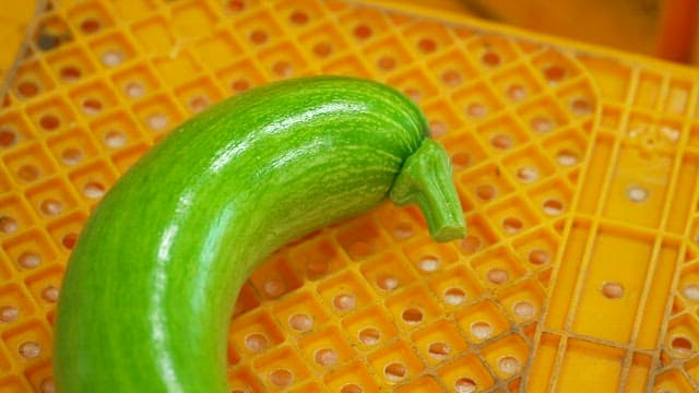 Green zucchini on a yellow plastic box