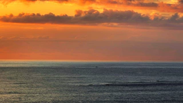 Serene ocean at sunset with vibrant sky