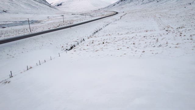 Snowy road winding through mountains