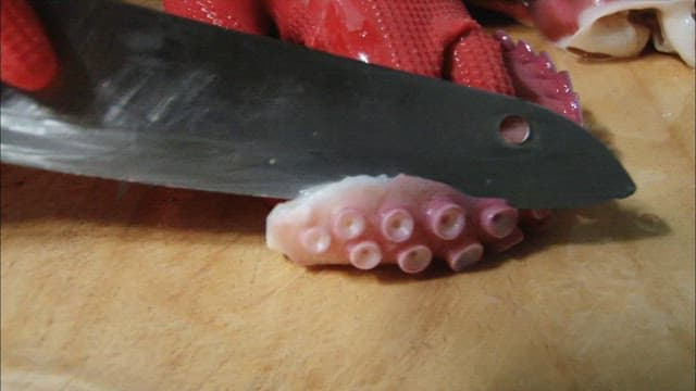 Cutting octopus tentacles on a cutting board