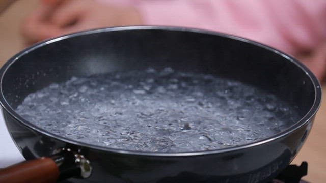 Fresh green onions placed in a pot of boiling water