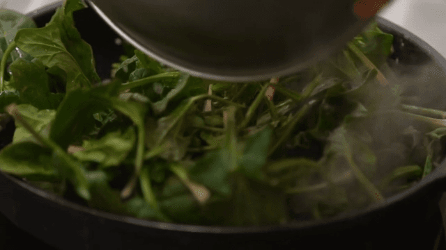Stir-frying bacon and spinach in a frying pan