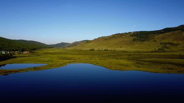 Vast green landscape with a calm lake
