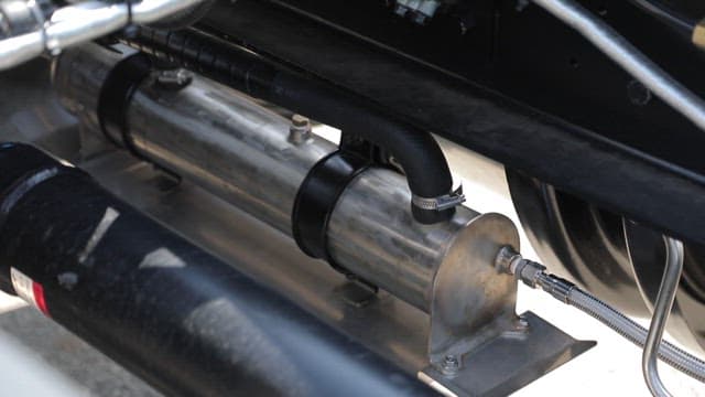 Metal pipe and components under a vehicle with bolts and clamps