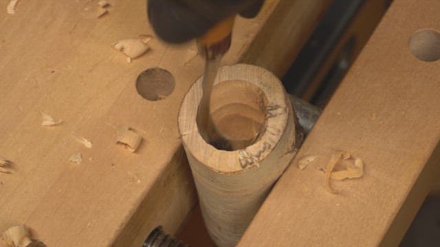 Wood carving with a chisel on a workbench