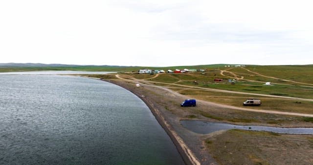 Serene lakeside with scattered vehicles