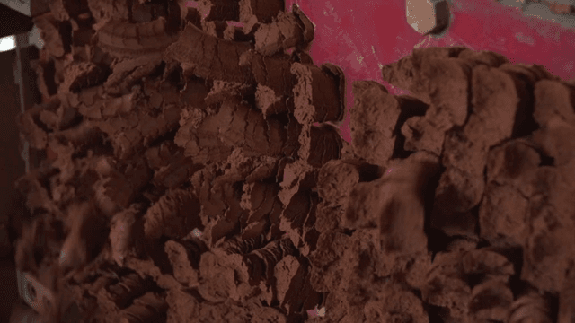 Brown clay being processed by machinery