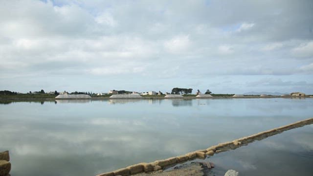 Vast salt pans under a cloud-filled sky