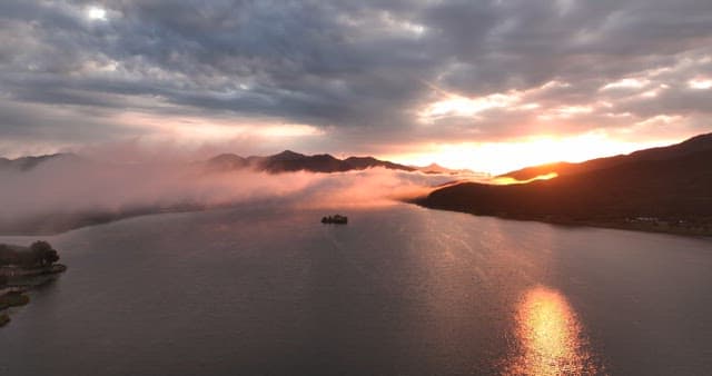 Sunrise over a misty river and mountains
