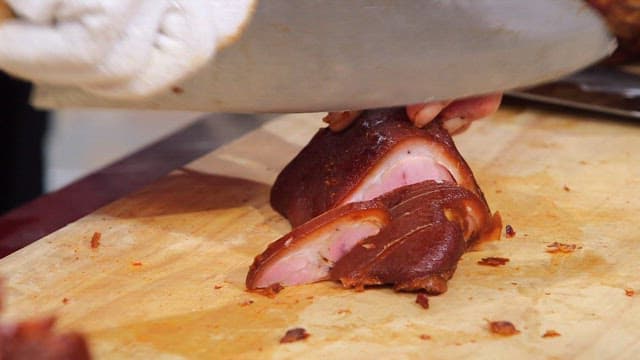 Cutting braised pigs' feet on a board