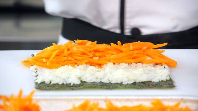 Preparing kimbap with carrots and mustard leaves
