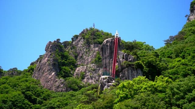 Red stairs on a mountain covered with green trees
