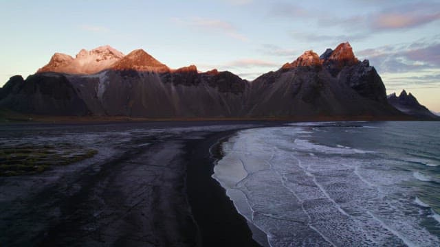 Serene beach with waves and mountains