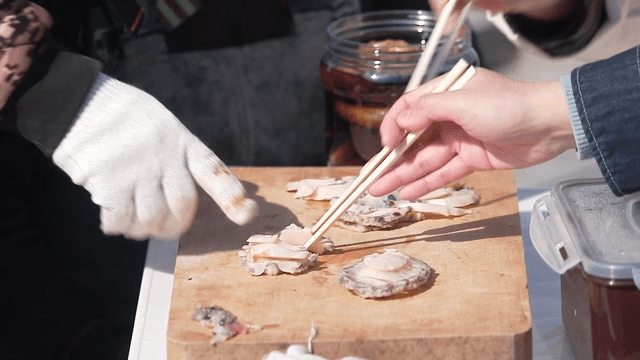 People eating freshly caught and prepared abalone raw abalone