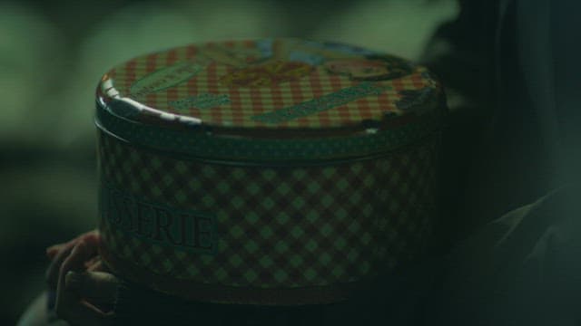 Dark night, hand holding a tin case