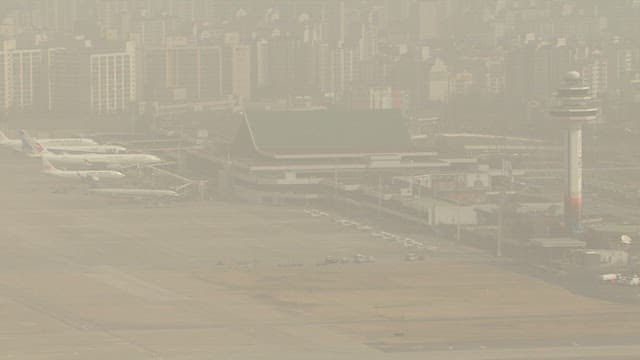 Airport with Airplanes and Cityscape in Hazy Atmosphere