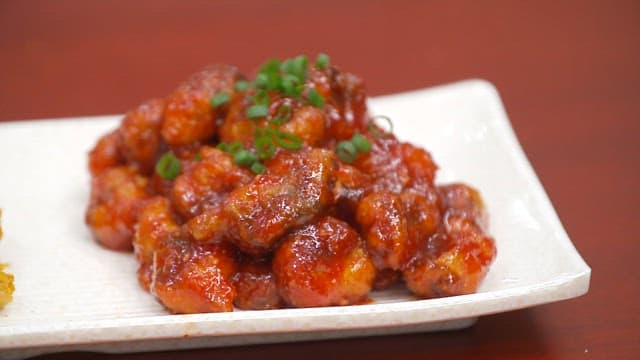 Two types of fried fish on a white plate