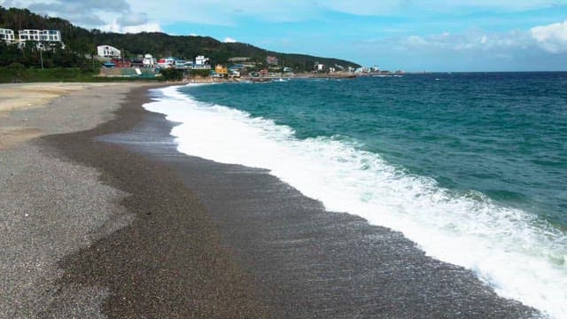 Serene beach with waves and coastal town
