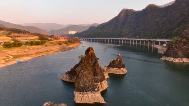 Scenic river with rocky islets and a bridge