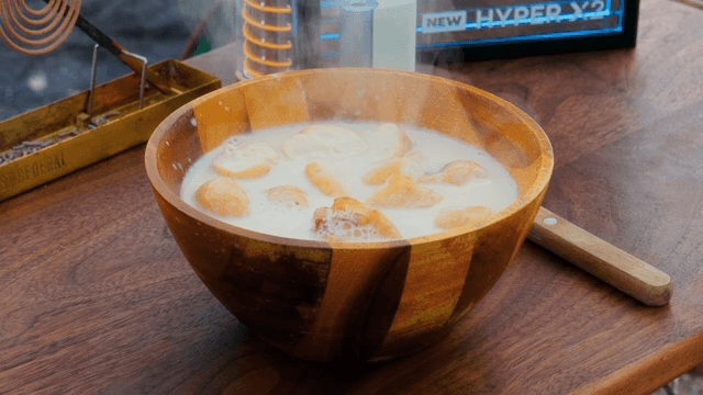 Warm soup and donuts prepared on a wooden table