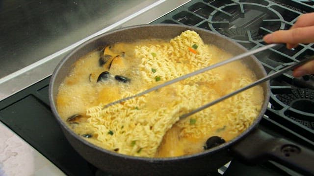 Cooking ramen with mussels in a pot
