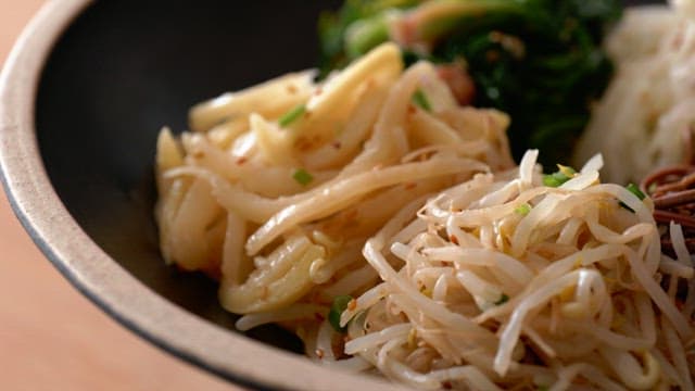 Various herbs in dark ceramic bowls