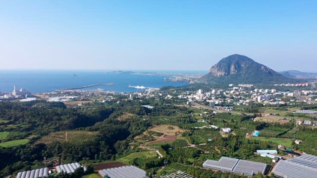 Village with a view of green farmland and coastline on a clear day
