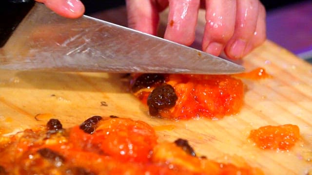 Slicing fresh sea pineapple on a wooden cutting board