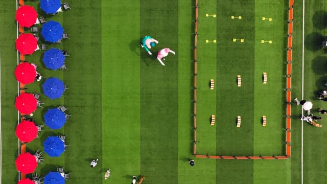 People gathered at the event venue with red and blue parasols