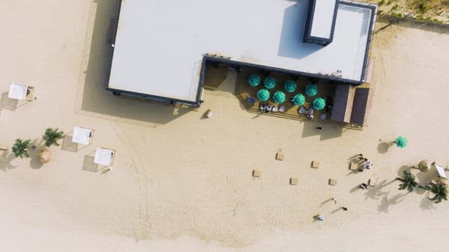 Aerial view of a beachfront pub with parasols