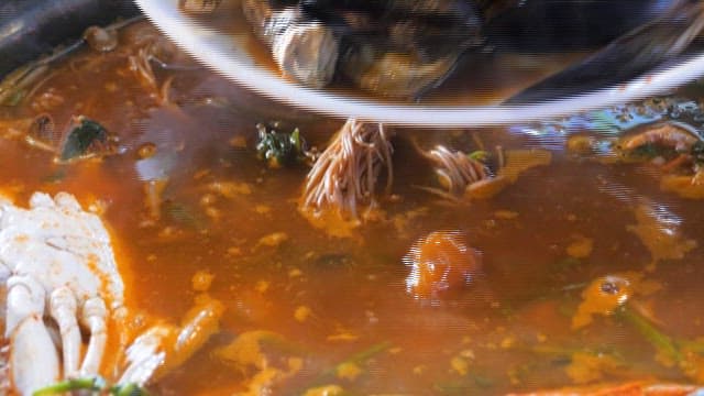 Spicy seafood stew preparation with fresh ingredients