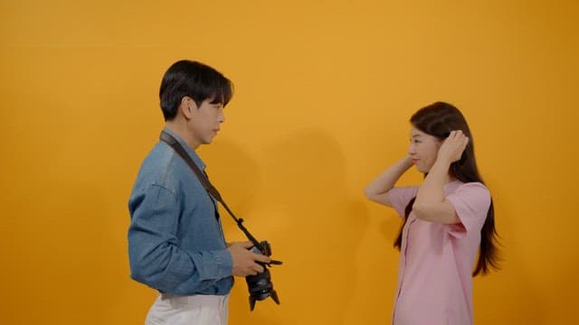 Male photographer taking pictures of female models with camera