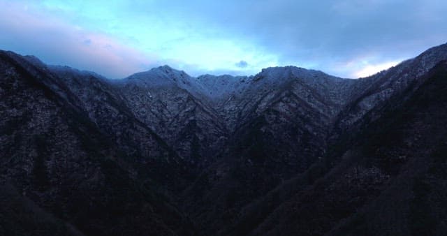Snow-covered mountains under cloudy skies