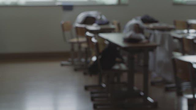 Empty classroom with messy desks and chairs