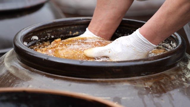Taking out fermented soybean bricks from a crock pot